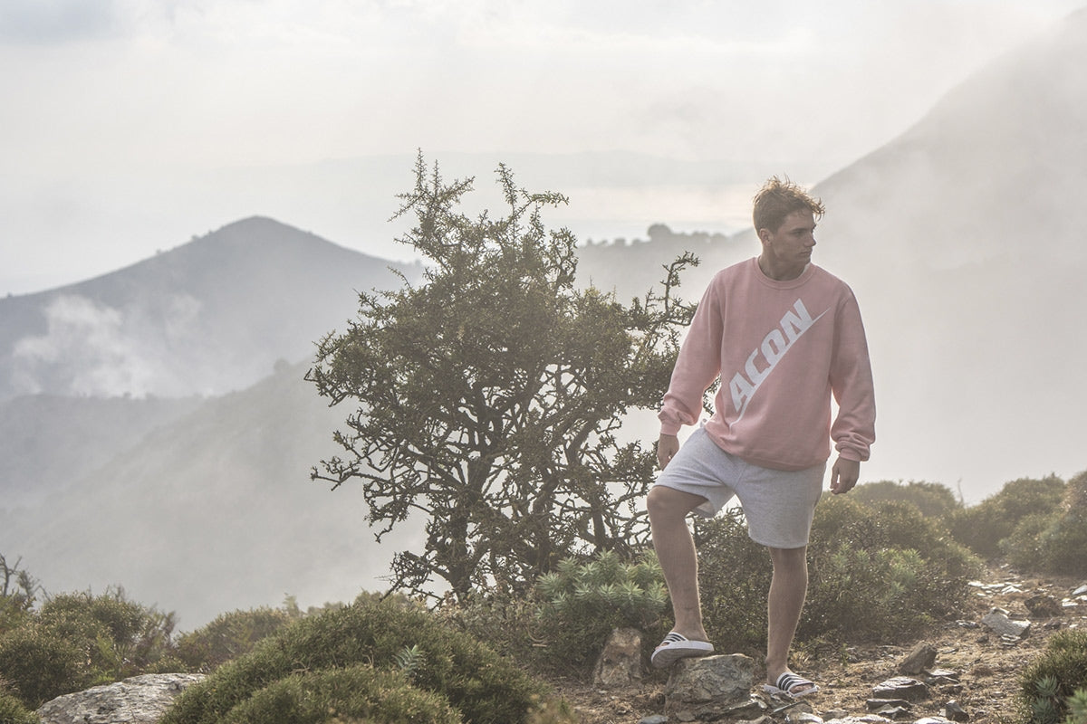 Un garçon portant un sweat-shirt ACON dans une vue de forêt