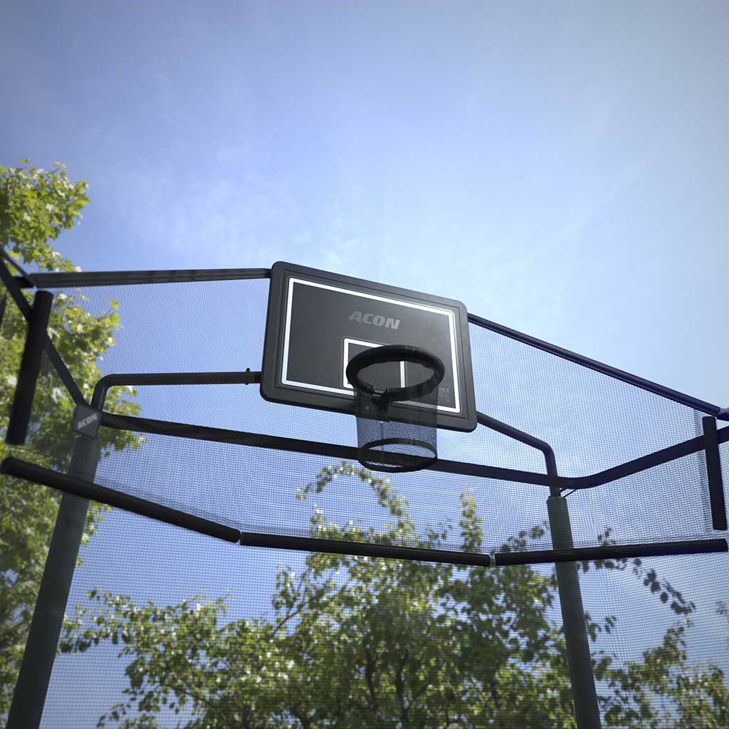 Photo du panier Acon pour trampolines rectangulaires et de son filet arrière, prise à l’extérieur, avec un cadrage en contre-plongée montrant un ciel bleu et les arbres environnants.