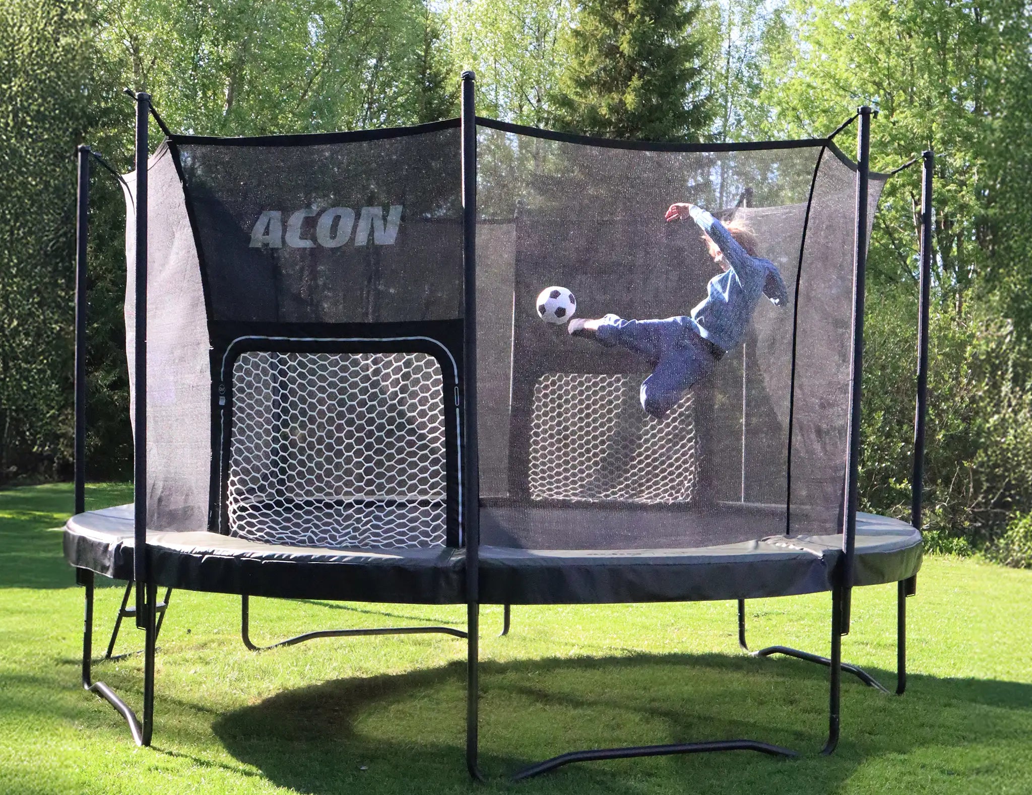Personne fait un tir au foot sur trampoline Acon avec filet pour jeu dans le jardin.