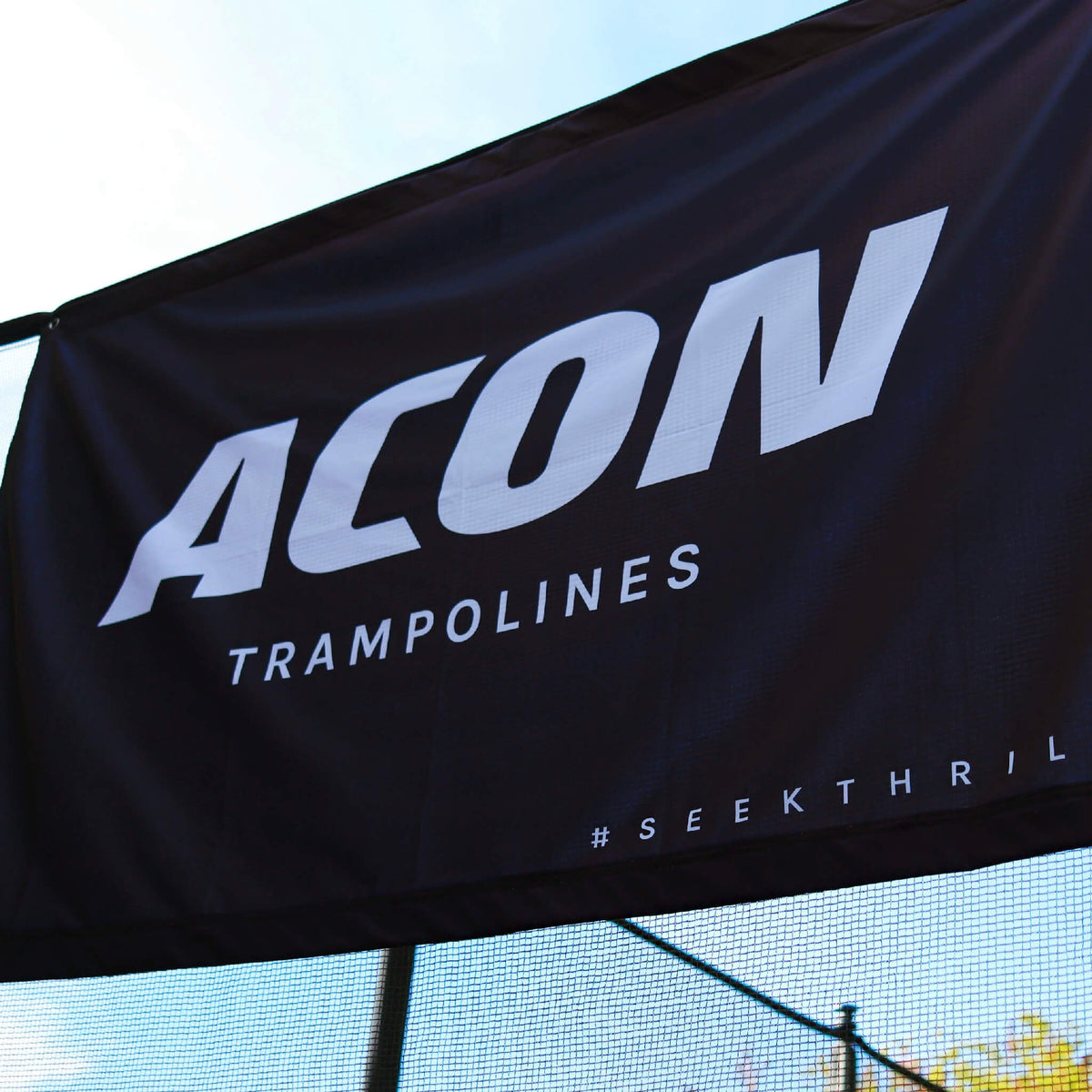 Gros plan du drapeau ACON noir sur le trampoline.