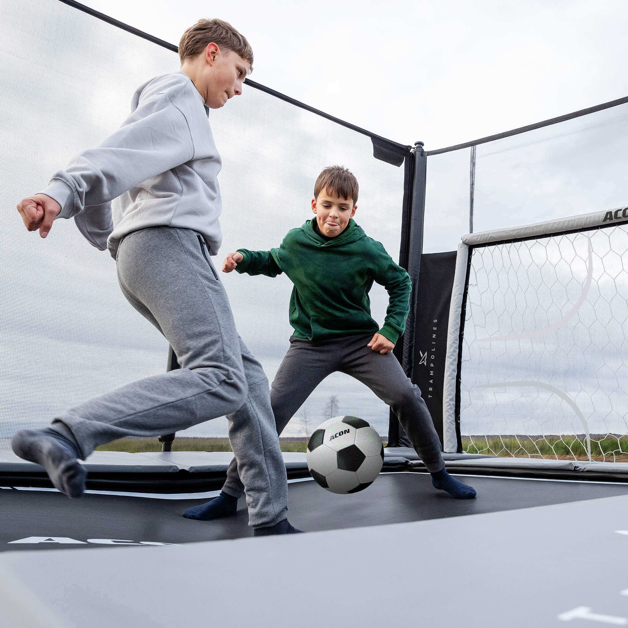 Deux garçons jouant au football sur un trampoline Acon X 17 avec peinture football