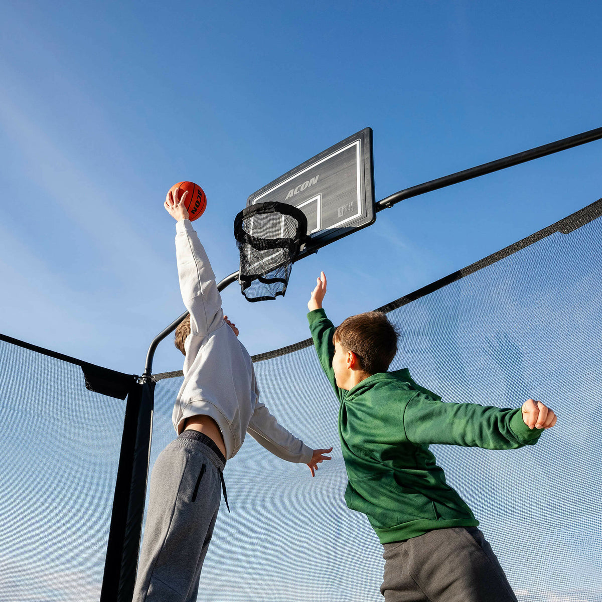 Deux garçons jouant au basket sur le trampoline Acon X.