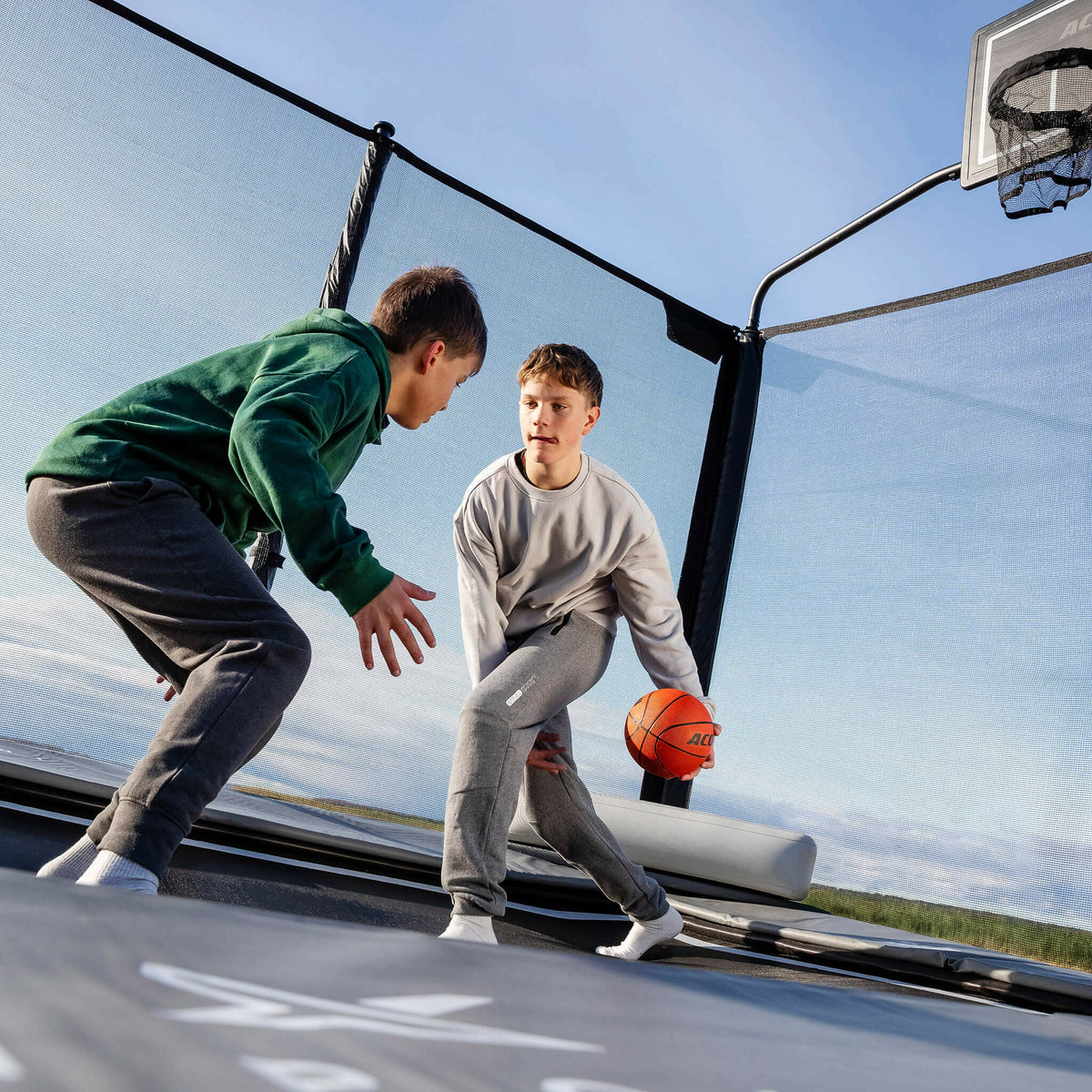 Deux garçons jouant au basket sur le trampoline Acon X.