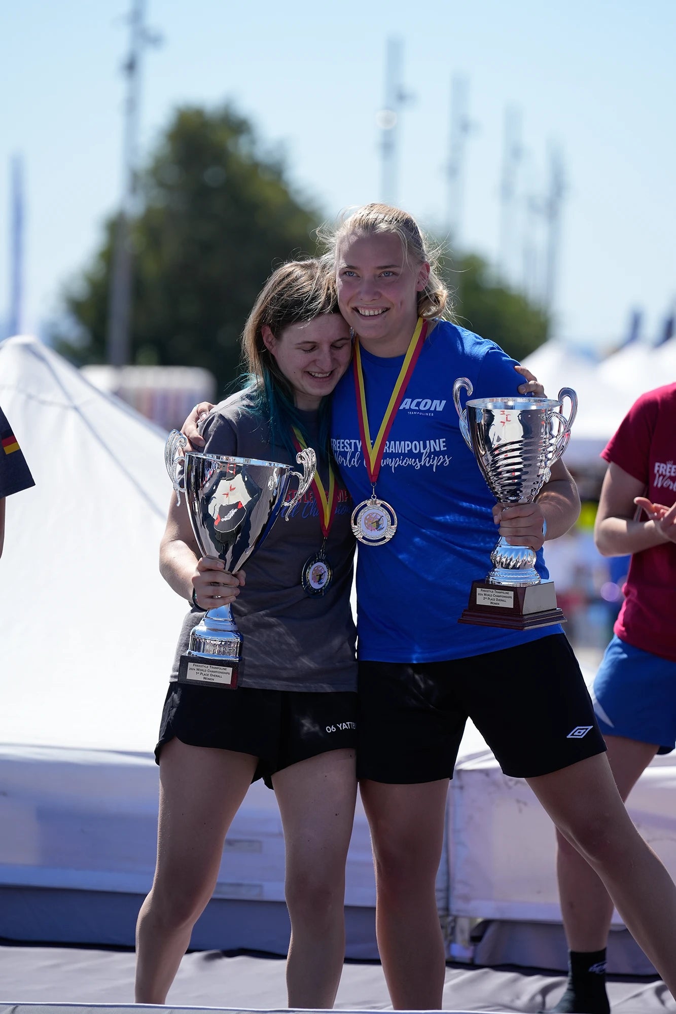 Les vainqueurs d’un concours de trampoline s’enlacent.