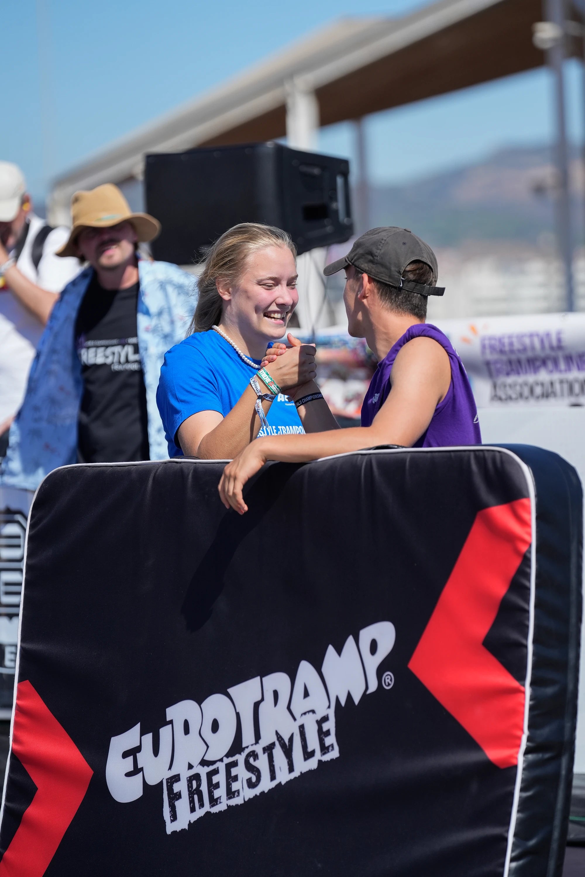 Des participants au concours de trampoline se serrent la main.