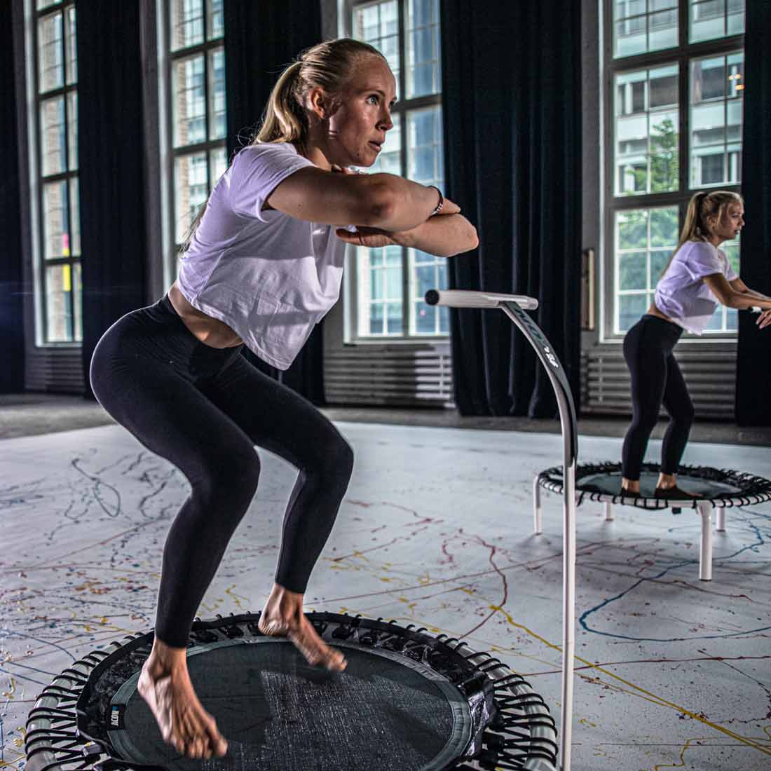 Des femmes font une séance de trampoline sur le trampoline blanc ACON FIT 1,12m, avec guidon