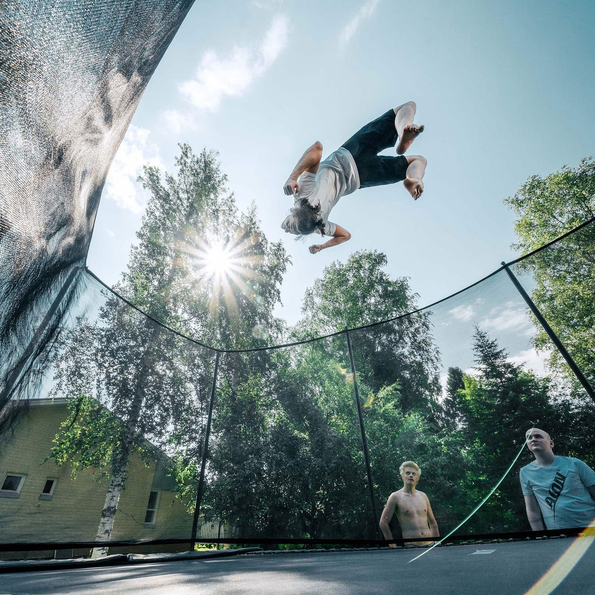 Tour de trampoline sur le trampoline Acon 16 HD PRO, les gars regardent.