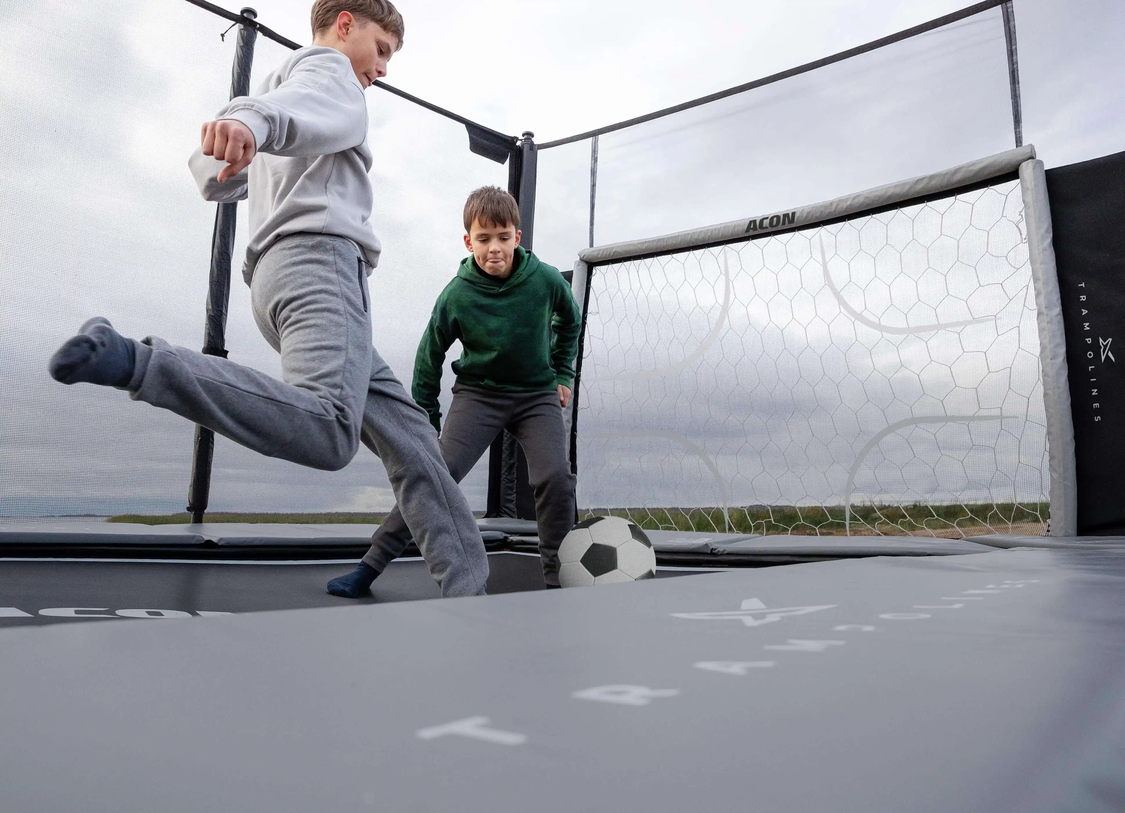 Deux garçons jouent au football sur trampoline sur le trampoline Acon X.
