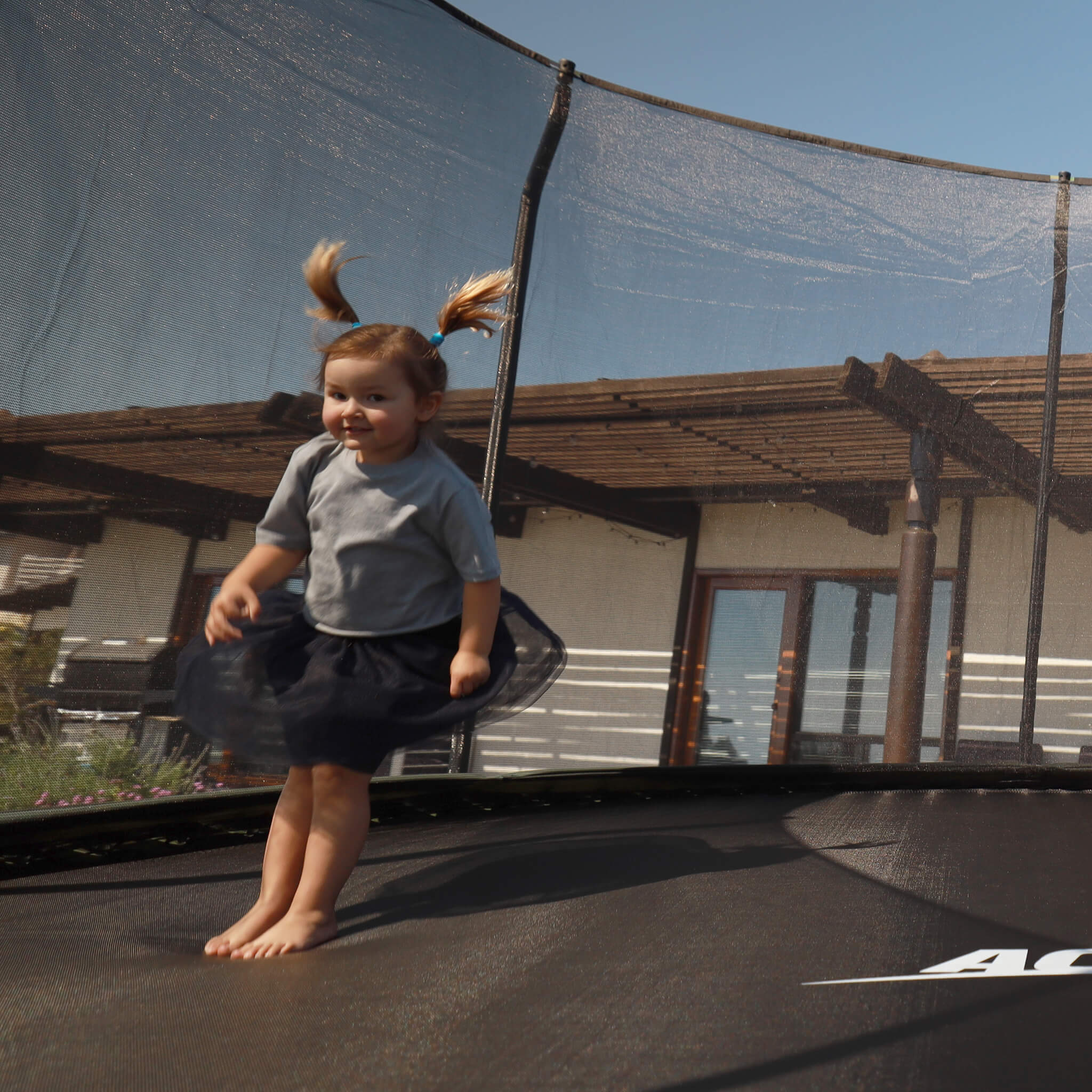 Un petit enfant saute sur un trampoline Acon.