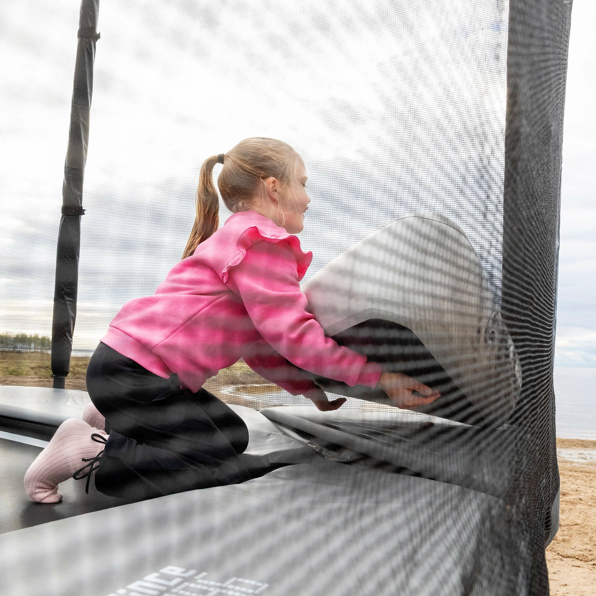 La fille installe le Triangle Block gonflable sur le trampoline Acon X.