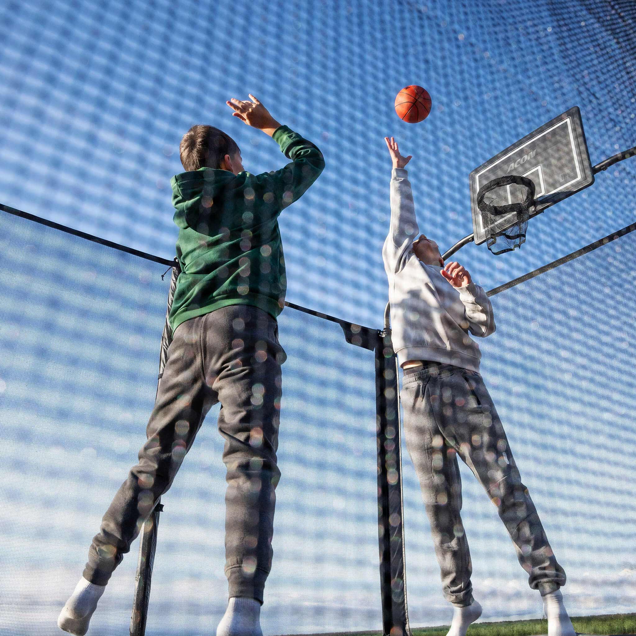 Deux garçons jouent au basket sur le trampoline Acon X.