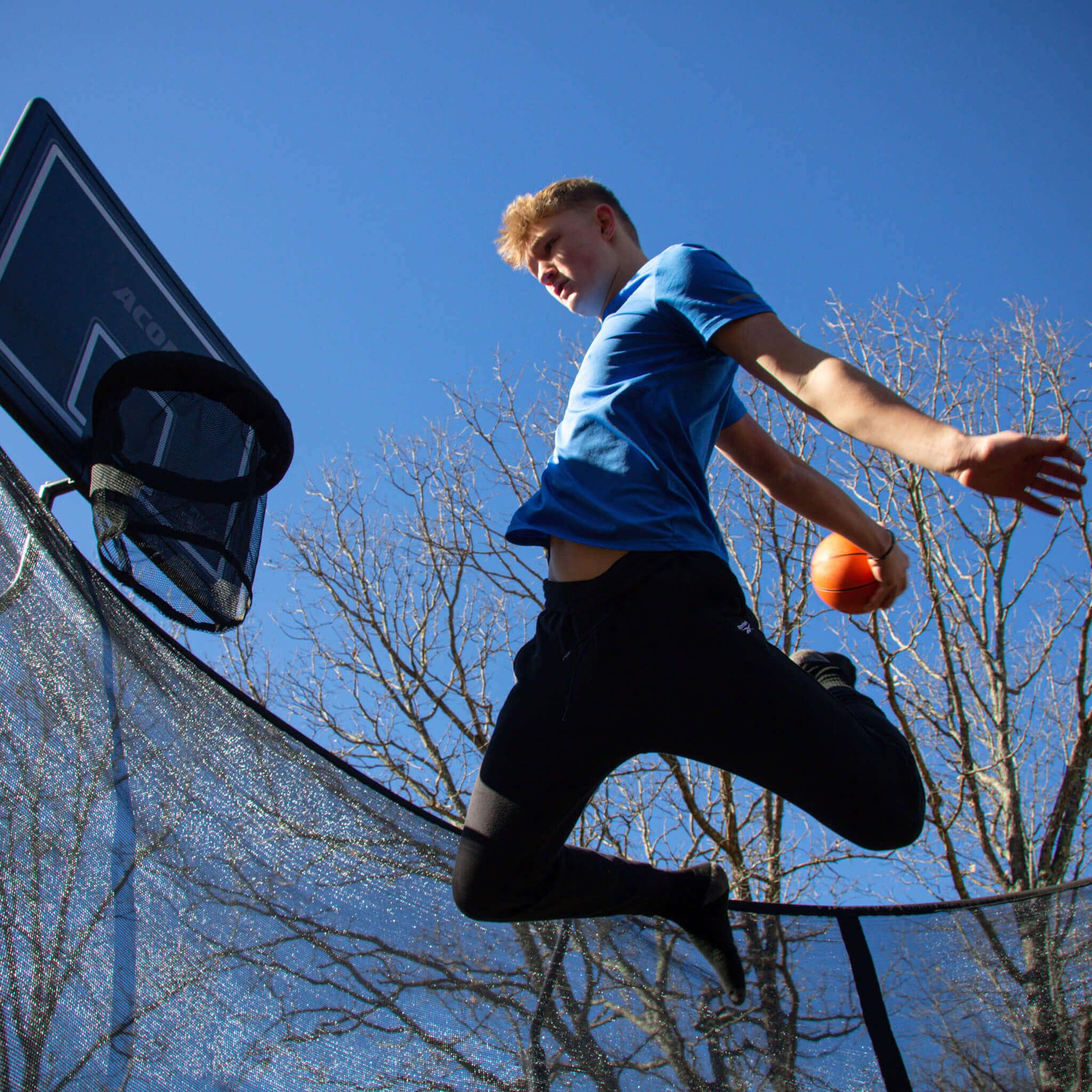 Joueur de basket-ball sur un trampoline rond.